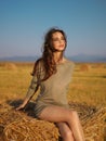 Young woman enjoying summer breeze hay stack