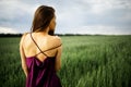 Beautiful young woman with long blonde hair in motion turned back, on the green field.Summer and freedom concept. Royalty Free Stock Photo