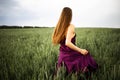 Beautiful young woman with long blonde hair in motion turned back, on the green field.Summer and freedom concept. Royalty Free Stock Photo