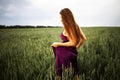 Beautiful young woman with long blonde hair in motion turned back, on the green field.Summer and freedom concept. Royalty Free Stock Photo