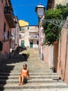 Young woman enjoying the sun in an alley of a small rural medieval village Royalty Free Stock Photo