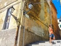 Young woman enjoying the sun in an alley of a small rural medieval village