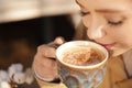 Young woman enjoying tasty coffee outdoors