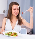 Young woman is enjoying tasty green salad Royalty Free Stock Photo