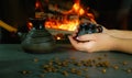 A young woman enjoys a coffee brewed in the traditional way in a ceramic dish. Close-up on hands against the background of burning Royalty Free Stock Photo