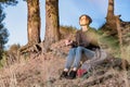 Young woman enjoys fine autumn weather. Female hiker sits under