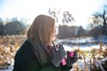 A young woman enjoys a hot drink from a thermos on a walk in winter. Royalty Free Stock Photo