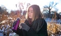 A young woman enjoys a hot drink from a thermos on a walk in winter. Royalty Free Stock Photo