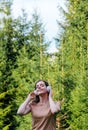 Young woman enjoys listening to music with headphones in forest in nature. Portrait young beautiful caucasian woman Royalty Free Stock Photo