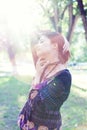 Young woman enjoys sun beams at spring park