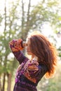 Young woman enjoys sun beams at spring park