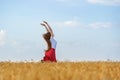 Young woman enjoys the sun and good weather are in middle of wheat field. Jumping for joy Royalty Free Stock Photo