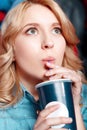 Young woman enthusiastically drinking coke in Royalty Free Stock Photo