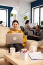 Young woman entrepreneur sitting on couch in middle of business start up office