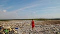 Young woman epicly standing over huge pile of trash