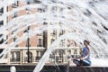 The young woman escaping heat wave in city fountain