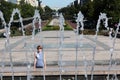 The young woman escaping heat wave in city fountain