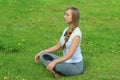 Young woman of European appearance does yoga in summer nature