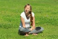 Young woman of European appearance does yoga in summer nature Royalty Free Stock Photo