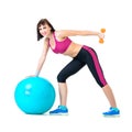 Young woman exercising with dumbbells on a fitness ball Royalty Free Stock Photo