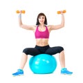 Young woman exercising with dumbbells on a fitness ball Royalty Free Stock Photo