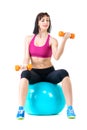 Young woman exercising with dumbbells on a fitness ball Royalty Free Stock Photo