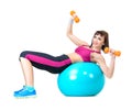 Young woman exercising with dumbbells laying on a fitness ball Royalty Free Stock Photo