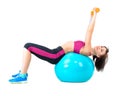 Young woman exercising with dumbbells laying on a fitness ball Royalty Free Stock Photo