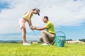 Young woman exercising the golf swing helped by her instructor Royalty Free Stock Photo