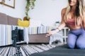 Young woman exercising at home doing workout and recording at her with cellular phone to teach workout and produce web class Royalty Free Stock Photo