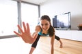 Young woman exercising at home, stretching legs and arms. Royalty Free Stock Photo