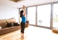 Young woman exercising at home, stretching legs and arms. Royalty Free Stock Photo