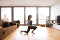 Young woman exercising at home, stretching legs. Royalty Free Stock Photo