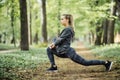 Young woman exercising at park during sunset. Beautiful athletic woman doing her stretches in the park. Sporty woman stretching af