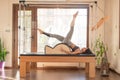 Young Woman Exercising on Pilates Reformer, Pilates Instructor