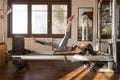 Young Woman Exercising on Pilates Reformer, Pilates Instructor
