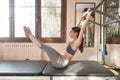 Young Woman Exercising on Pilates Reformer, Pilates Instructor