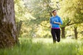 Young Woman Exercising Running Through Countryside Field