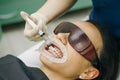 Young woman with an expander in mouth at the dental clinic. Beautiful smile. The health of teeth. Dentist stomatologist