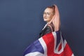 Young woman expat in eyeglasses with great britain flag. Studio shot. English language hipster teacher