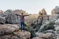 Young woman explorer with open arms looking at the mountains.