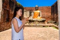 Young woman is exploring the ancient ruins of a buddhist temple