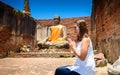 Young woman is exploring the ancient ruins of a buddhist temple