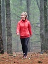 Young woman exploring stunning autumn foggy forest