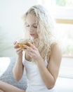 Young woman with eyes closed enjoying herbal tea in house