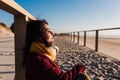 Young woman with eyes closed relaxing at beach at sunset. Holidays and relaxation concept Royalty Free Stock Photo