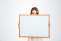 Young woman with eyes wide open peeping from blank board Royalty Free Stock Photo
