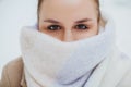 Young woman face covered with light colored knitted scarf Royalty Free Stock Photo