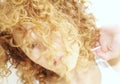 Young woman with face hidden by curly hair