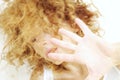 Young woman with face hidden by curly hair